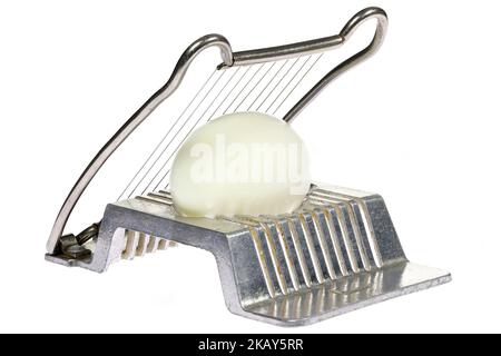 vintage aluminium egg slicer with hard-boiled chicken egg isolated on white background Stock Photo