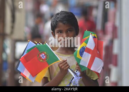 A boy sales flag of different countries on street ahead of the FIFA World Cup 2018 in Dimapur, India north eastern state of Nagaland on Monday June 11, 2018. (Photo by Caisii Mao/NurPhoto) Stock Photo