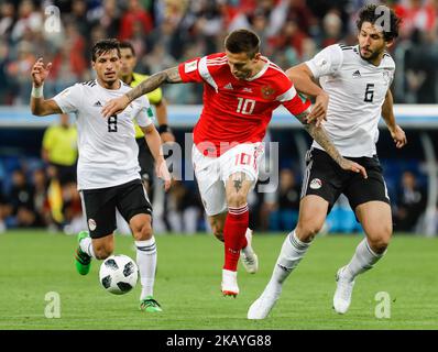 Fedor Smolov (C) of Russia national team vies for the ball with Tarek Hamed (L) and Ahmed Hegazy of Egypt national team during the 2018 FIFA World Cup Russia group A match between Russia and Egypt on June 19, 2018 at Saint Petersburg Stadium in Saint Petersburg, Russia. (Photo by Mike Kireev/NurPhoto) Stock Photo