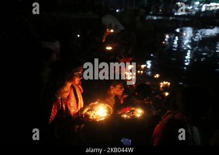 Dhaka, Bangladesh. Bangladeshi Hindu devotee women hold oil lamps to release to the Buriganga River as they attend Bipottarini Puja in Dhaka, Bangladesh, July 17, 2018. (Photo by Rehman Asad/NurPhoto) Stock Photo