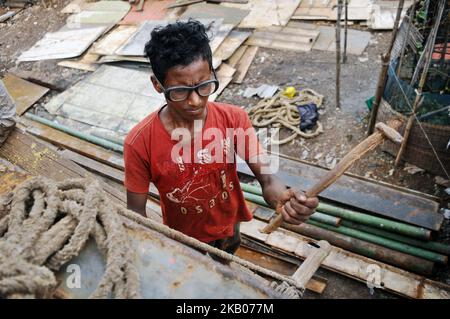 Jewel (13) , working as a labour in shipyard for 8 months. Photo has taken on Monday 23 July 2018 from keranigonj shipyard, Dhaka , Bangladesh. According to the labor law in Bangladesh the minimum age for employment is 14 years. The enforcement of such labor law is virtually impossible in Bangladesh because most of the children are employed in internal sectors such as small factories , workshop, on the street, homemade business and domestic employment. (Photo by Syed Mahamudur Rahman/NurPhoto) Stock Photo