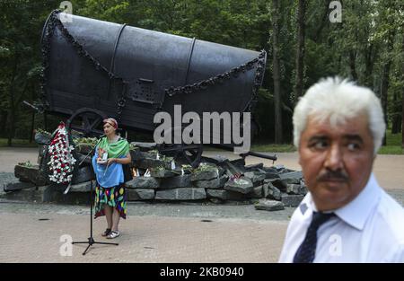 People attend a remembrance ceremony at the Nomad-caravan memorial of the victims of Holocaust in Kyiv, Ukraine, August 2,2018. Roma Holocaust Memorial Day, held every year on August 2, remembers the murders of hundreds of thousands of Romani by the Nazis and their allies during World War II. (Photo by Sergii Kharchenko/NurPhoto) Stock Photo