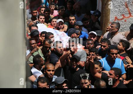 Palestinian mourners carry the body of 23 year-old Hamas fighter, Ahmad Morjan, during his funeral, in the Jabaliya refugee camp, Northern Gaza Strip, Tuesday, Aug. 7, 2018. The Israeli military said it targeted a Hamas military post in northern Gaza after militants opened fire, and Hamas said two of its fighters were killed. (Photo by Majdi Fathi/NurPhoto) Stock Photo