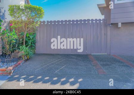 White wooden fence at the front yard of a home in San Francisco California. Exterior view of a closed gate that leads to the interior of a private res Stock Photo