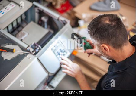 All machines nead maintains. Professional technician troubleshooting and repair the machines in the printing house. Stock Photo