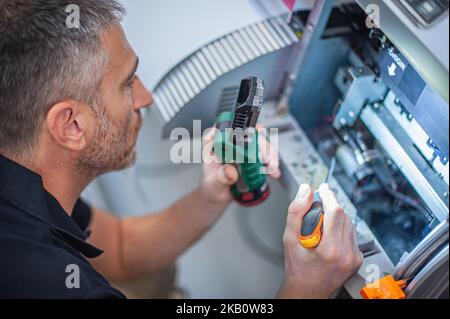 All machines nead maintains. Professional technician troubleshooting and repair the machines in the printing house. Stock Photo