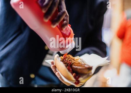 Close-up of a hotdog, sausage in a roll ketchup been poured over the sausage and onions Stock Photo