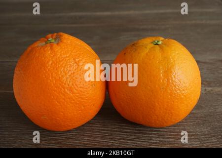 two oranges isolated on wooden table Stock Photo