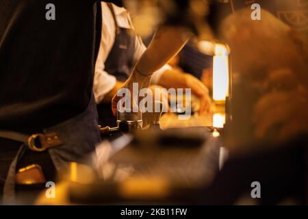 Close-up of the Barista tampering freshly ground coffee into a porta filter Stock Photo