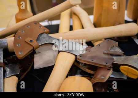 Handmade axes with leather hatchet blade cover on counter of craft fair Stock Photo