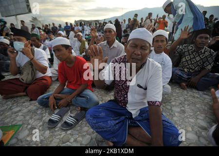Indonesian Muslims pray in special prayers for victims of the earthquake and tsunami at the Talise beach in Palu, Central Sulawesi, Friday, October 5, 2018. Hundreds of Muslims who survived in the Indonesian city of Palu gathered at the mosque mosques were destroyed for prayer, seeking strength to rebuild their lives a week after a devastating earthquake and tsunami killed more than 1,500 people. (Photo by Dasril Roszandi/NurPhoto) Stock Photo