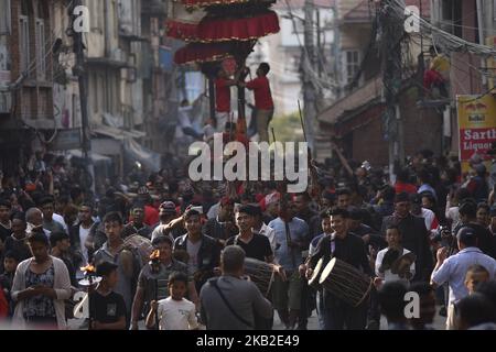 Devotees playing traditional drums as Locals carry and rotates top part of a chariot of Lord Narayan across the streets of Hadigaun during Lord Narayan jatra festival in Hadigaun, Kathmandu, Nepal on Thursday, October 25, 2018. Once in a every year right after Dashain Festival this festival celebrates. The Narayan Jatra Festival of Hadigaun is a unique Festival in the capital involving three circular bamboo structures, above which an idol of the Lord Narayan in placed, and then rotated by two people standing below. (Photo by Narayan Maharjan/NurPhoto) Stock Photo