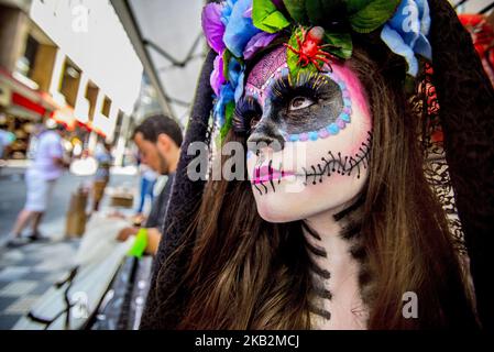 Girl with fantasy and catrina makeup shakes up transeuentes and consumers at Ladeira Porto Geral on 31 October 2018 in Sao Paulo, Brazil. La Catrina de los toletes, in Mexican popular culture, is the representation of the skeleton of a lady of high society. She is one of the most popular figures of the Day of the Dead party in Mexico. (Photo by Cris Faga/NurPhoto) Stock Photo