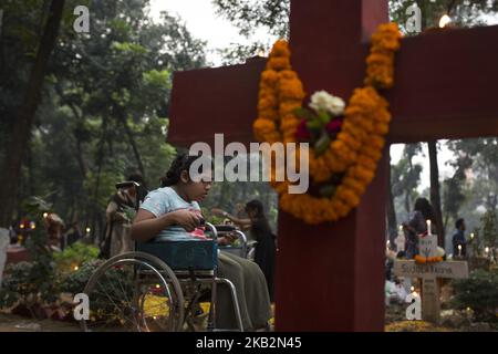 Christian devotees observe All Souls' Day, known as the Feast of All Souls, Commemoration of all the Faithful Departed in Dhaka , Bangladesh on November 02, 2018. On this day, Christians come to the graveyard and pray for the departed souls of their loved ones..All Soul's Day is a Roman Catholic day of remembrance for friends and loved ones who have passed away. This comes from the ancient Pagan Festival of the Dead, which celebrated the Pagan belief that the souls of the dead would return for a meal with the family. Candles in the window would guide the souls back home, and another place was  Stock Photo