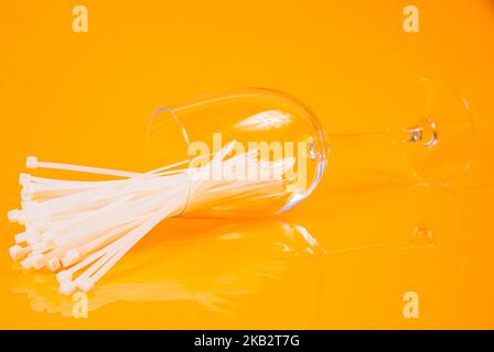 nylon cable ties in glass in jar in bucket on orange background front top view isolated Stock Photo