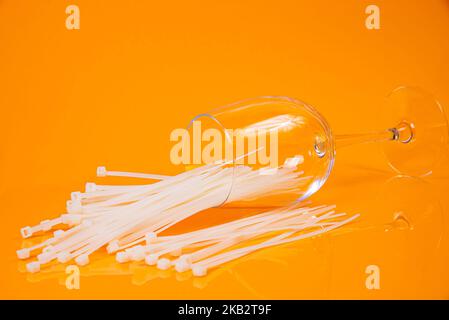 nylon cable ties in glass in jar in bucket on orange background front top view isolated Stock Photo