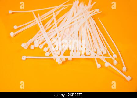 nylon cable ties in glass in jar in bucket on orange background front top view isolated Stock Photo