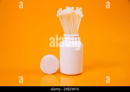 nylon cable ties in glass in jar in bucket on orange background front top view isolated Stock Photo