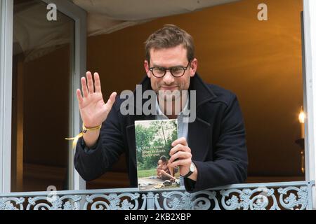 French writer Nicolas Mathieu (C) poses with his book 'Leurs enfants apres eux' on the balcony of Drouant restaurant after winning the Prix Goncourt, France's top literary prize, on November 7, 2018 in Paris. (Photo by Michel Stoupak/NurPhoto) Stock Photo