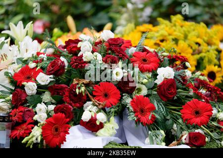 roses, gerbera, lilies and sunflowers on a grave after a funeral Stock Photo