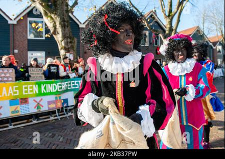 November 17th, Zaanstad. Like each year the first Saturday after 11 November, the red-and-white-clad Sinterklaas (St. Nicholas) arrives by steamboat to great fanfare. The national arrival of Sinterklaas is in North Holland, Zaanstad, in the Zaanse Schans. Around 25.000 visitors turn out along the canals to greet the tall, bearded saint and his helpers, jolly types called “Zwarte Pieten” or “Black Petes.” (Photo by Romy Arroyo Fernandez/NurPhoto) Stock Photo