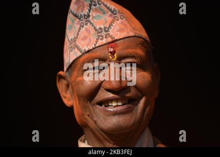 A smiling Portrait of an old man full of colors during the celebration of Mahalaxmi Festival at Thankot, Kathmandu, Nepal on Saturday, November 24, 2018. Mahalaxmi Festival is the annual festival to honor of the goddess Mahalaxmi and Ganesh are carried to the Mahalaxmi temple. A vermillion power and red colored powder, is thrown on participants and chariots as festival is accompanied by traditional music and dance. (Photo by Narayan Maharjan/NurPhoto) Stock Photo