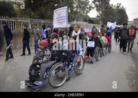 Nepalese disabled people on wheelchairs hold placards in a rally during 27th International Day of Persons with Disabilities in Kathmandu, Nepal on Monday, December 03, 2018. The 27th World Disability Day focuses on 'Empowering persons with disabilities and ensuring inclusiveness and equality'. (Photo by Narayan Maharjan/NurPhoto) Stock Photo