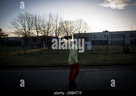 Italy, Rome: A migrant walks next to the fence of Castelnuovo di Porto migrants center, some 10 kilometers north of Rome, on January 23, 2019. Almost 500 Migrants are being transferred following the decision to close Italy's second largest state-run reception center Cara (Reception center for asylum seekers). (Photo by Christian Minelli/NurPhoto) Stock Photo