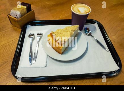 Breakfast with sweet cheesecake slice on a plate and a cup of coffeee on a wooden table Stock Photo