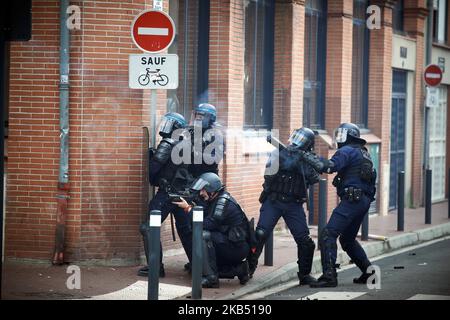 Riot policemen in action, one of them prepares to launch flashballs on protesters as another one just launches tear gas canisters. For the Act XI of the Yellow Vest movement, more than 10 000 people took to the streets of Toulouse for the anti-governement protest. Skirmishes took place between protesters and riot police during 3 hours. Riot police used of tear gas canister and one police water cannon. The Yellow Jackets movement begun on November 17th by a protest against the rise of taxes on oil products. The rise of taxes was the detonator of their wrath against French President Macron and h Stock Photo