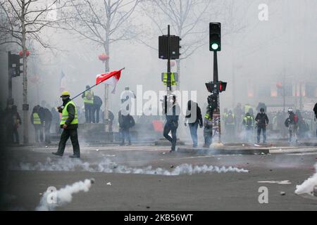 Protestors run in tear gas during a demonstration called by the 'Yellow Vests' ('Gilets Jaunes') movement in Paris, on February 2, 2019. The 'Yellow Vest' (Gilets Jaunes) movement called to pacifically protest against police violence toward participants of the last three months demonstrations in France and for the bam of the use by riot police of both 40-millimetre rubber defencive bullet launcher LBD and GLI-F4 stun grenades, as 'Yellow Vest' (Gilets Jaunes) protesters take to the streets for the 12th consecutive Saturday. (Photo by Michel Stoupak/NurPhoto) Stock Photo