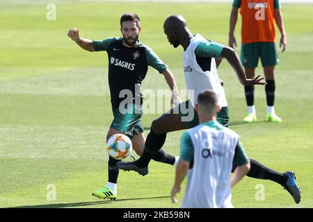 Portugal's midfielder Danilo (R ) and midfielder Joao Moutinho (L) in action on during a training session at Cidade do Futebol (Football City) training camp in Oeiras, outskirts of Lisbon, Portugal, on September 4, 2019, ahead of the UEFA EURO 2020 qualifier matches against Serbia and Lithuania. (Photo by Pedro FiÃºza/NurPhoto) Stock Photo