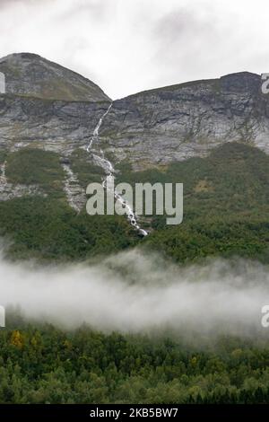 Beautiful waterfalls inside intense nature in dramatic scenery with clouds or green forest natural environment, seen at the fjords in Norway with forests and steep mountains. Water coming from high altitude mountain peaks and glaciers ending up throughValldola river to the fjords and the sea at the area of Valldal and Valldalen valley on 31 August 2019. (Photo by Nicolas Economou/NurPhoto) Stock Photo