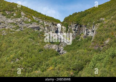Beautiful waterfalls inside intense nature in dramatic scenery with clouds or green forest natural environment, seen at the fjords in Norway with forests and steep mountains. Water coming from high altitude mountain peaks and glaciers ending up throughValldola river to the fjords and the sea at the area of Valldal and Valldalen valley on 31 August 2019. (Photo by Nicolas Economou/NurPhoto) Stock Photo