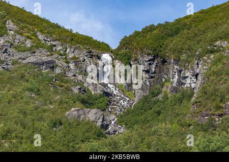 Beautiful waterfalls inside intense nature in dramatic scenery with clouds or green forest natural environment, seen at the fjords in Norway with forests and steep mountains. Water coming from high altitude mountain peaks and glaciers ending up throughValldola river to the fjords and the sea at the area of Valldal and Valldalen valley on 31 August 2019. (Photo by Nicolas Economou/NurPhoto) Stock Photo