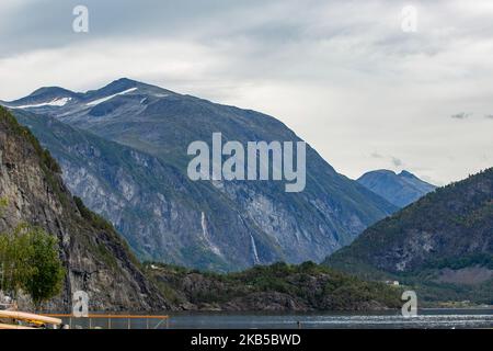 Beautiful waterfalls inside intense nature in dramatic scenery with clouds or green forest natural environment, seen at the fjords in Norway with forests and steep mountains. Water coming from high altitude mountain peaks and glaciers ending up throughValldola river to the fjords and the sea at the area of Valldal and Valldalen valley on 31 August 2019. (Photo by Nicolas Economou/NurPhoto) Stock Photo