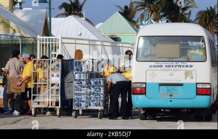 Crew members of Royal Caribbean International's Mariner of the Seas load cases of drinking water and prepared meals for Hurricane Dorian victims into a church bus on September 7, 2019 in Freeport, Bahamas. The ship is also providing an estimated 300 Freeport evacuees of the storm with food, water, an opportunity to take a shower, as well as transportation to Nassau, New Providence. (Photo by Paul Hennessy/NurPhoto) Stock Photo