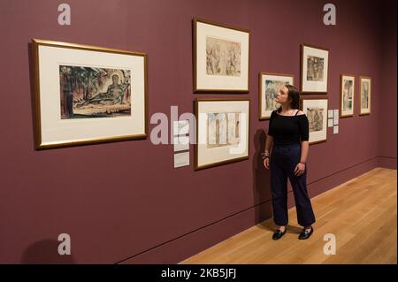 A gallery staff member views late works by British artist William Blake (1757-1827) including illustration for The Divine Comedy by Dante Alighieri (Inferno XIV, 46-72) 'Capaneus the Blasphemer' (1824-1827) (1st left) during a photocall to promote the upcoming exhibition at the Tate Britain on 09 September, 2019 in London, England. The exhibition presents the largest survey of work by William Blake in the UK for a generation, bringing together over 300 remarkable and rarely seen works of the visionary painter, printmaker and poet. (Photo by WIktor Szymanowicz/NurPhoto) Stock Photo