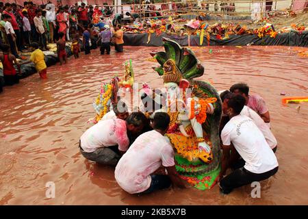 Devotees immerse an idol of Lord Ganesh in the water pond created by the Delhi Government on the last day of the Ganesh Chaturthi festival, at Geeta Colony on September 12, 2019 in New Delhi, India. (Photo by Mayank Makhija/NurPhoto) Stock Photo