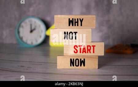 Why not start now symbol. Concept words Why not start now on wooden blocks. Beautiful white background. Businessman hand. Business and Why not start n Stock Photo