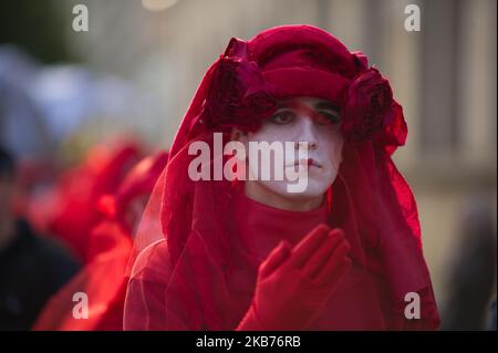 Extinction Rebellion activists are seen performing as Red Rebellion Brigade in a silent march on September 28, 2019 in Warsaw, Poland. The group is the brainchild of Doug Francisco, founder of The Invisible Circus launched as a street performance group. Their aim is to raise awarness about climate crisis by affecting the viewer with their appearance and slow movements. (Photo by Aleksander Kalka/NurPhoto) Stock Photo