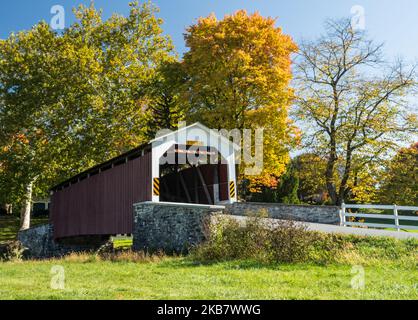 Erb’s Covered Bridge in Autumn. This is a beautiful red covered bridge in Lancaster County, Pennsylvania Stock Photo