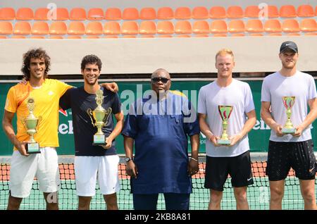 Tunisians Skander Monsouri (L) and Aziz Dougaz (2nd-L) pose with trophy after winners of the Men's Double final against Zimbabwe brothers, Benjamin Lock (2nd-R) and Courtney Lock (R) on 14th October 2019 in Lagos, Nigeria. (Photo by Olukayode Jaiyeola/NurPhoto) Stock Photo