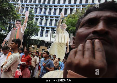 A man stands in front of a banner featuring an image of India's Prime Minister Narendra Modi and Maharashtra state Chief Minister Devendra Fadnavis outside the Bhartiya Janata Party (BJP) headquarters in Mumbai, India on 24 October 2019. (Photo by Himanshu Bhatt/NurPhoto) Stock Photo
