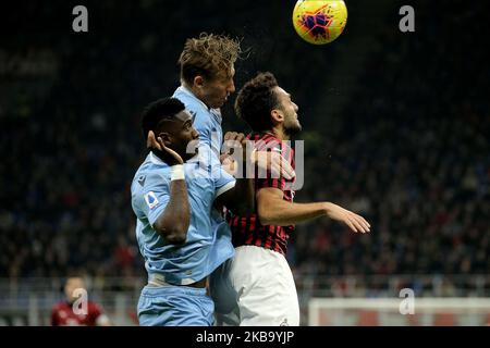 Hakan Calhanoglu of AC Milan competes for the ball with Bastos of SS Lazio and Lucas Leiva of SS Lazio during the Serie A match between AC Milan and SS Lazio at Stadio Giuseppe Meazza on November 3, 2019 in Milan, Italy. (Photo by Giuseppe Cottini/NurPhoto) Stock Photo