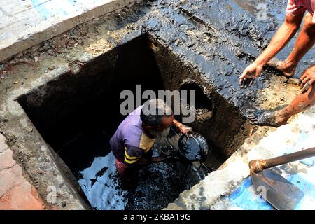 Bangladeshi sewer cleaner cleans road manholes in Dhaka, Bangladesh, on November 04, 2019. Sewer cleaners earn 6 to 10 US dollar a day as they doing risky, worst job in Dhaka. Increase the number of deaths of manhole sewer workers every year, because they don't have proper safety equipment for regularly work in the manholes. (Photo by Mamunur Rashid/NurPhoto) Stock Photo