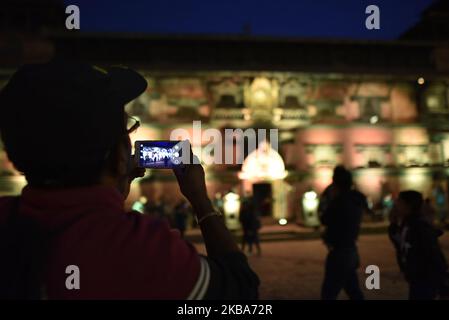 A Nepalese Youth takes pictures of Heritage and Monuments Sites of Patan Durbar Square decorated with colorful light in Lalitpur, Nepal on Wednesday, November 06, 2019. Patan Durbar Square is one of the three Durbar Squares in the Kathmandu Valley, which is listed in the UNESCO World Heritage Sites. (Photo by Narayan Maharjan/NurPhoto) Stock Photo