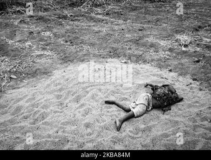 (EDITOR'S NOTE: Image was converted to black and white) A boy plays in a sand pile in Central Malawi. Malawi is one of the poorest countries in the world with 50.7 percent of the population living below the poverty line and 25 percent living in extreme poverty. Efforts to reduce poverty have failed to yield the desired results due in part to a rapid population growth that erodes the marginal gains from economic growth. Central Malawi, 2017. (Photo by John Fredricks/NurPhoto) Stock Photo