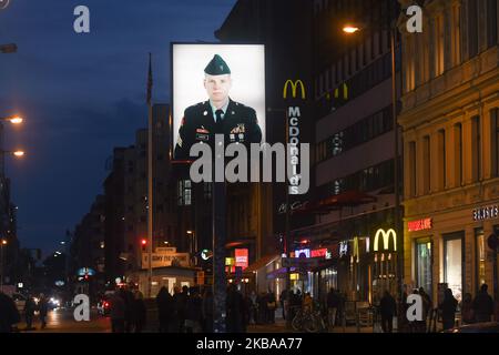 A portrait of a U.S. soldier stands illuminated at former Checkpoint Charlie, where U.S. and Soviet tanks confronted each other in the early years of the Cold War, seen just two days ahead of the upcoming 30th anniversary of the fall of the Berlin Wall. The Berlin Wall divided the German capital from 1961 until 1989. Checkpoint Charlie was a main crossing point at the Wall from the American Sector in West Berlin into the Russian sector in East Berlin. On Thursday, November 7, 2019, in Berlin, Germany. (Photo by Artur Widak/NurPhoto) Stock Photo
