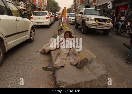 A ragpicker sleeps on a road divider after a hectic day of work in New Delhi, India on October 19, 2019. (Photo by Mayank Makhija/NurPhoto) Stock Photo